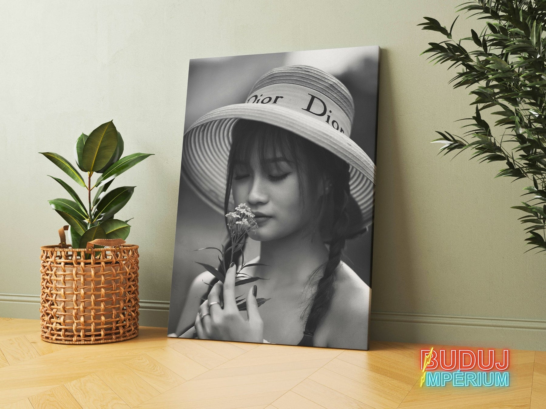 Modern canvas print with a black and white portrait of a woman in a hat holding a flower in a modern interior