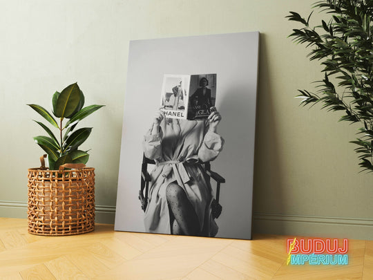 Motivational canvas wall art with a black and white woman in a director’s chair, a fashion magazine and an indoor plant.