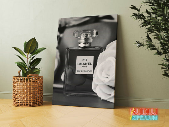 Motivational canvas wall art with a black and white perfume bottle and rose in an interior, a minimalist lifestyle motif.