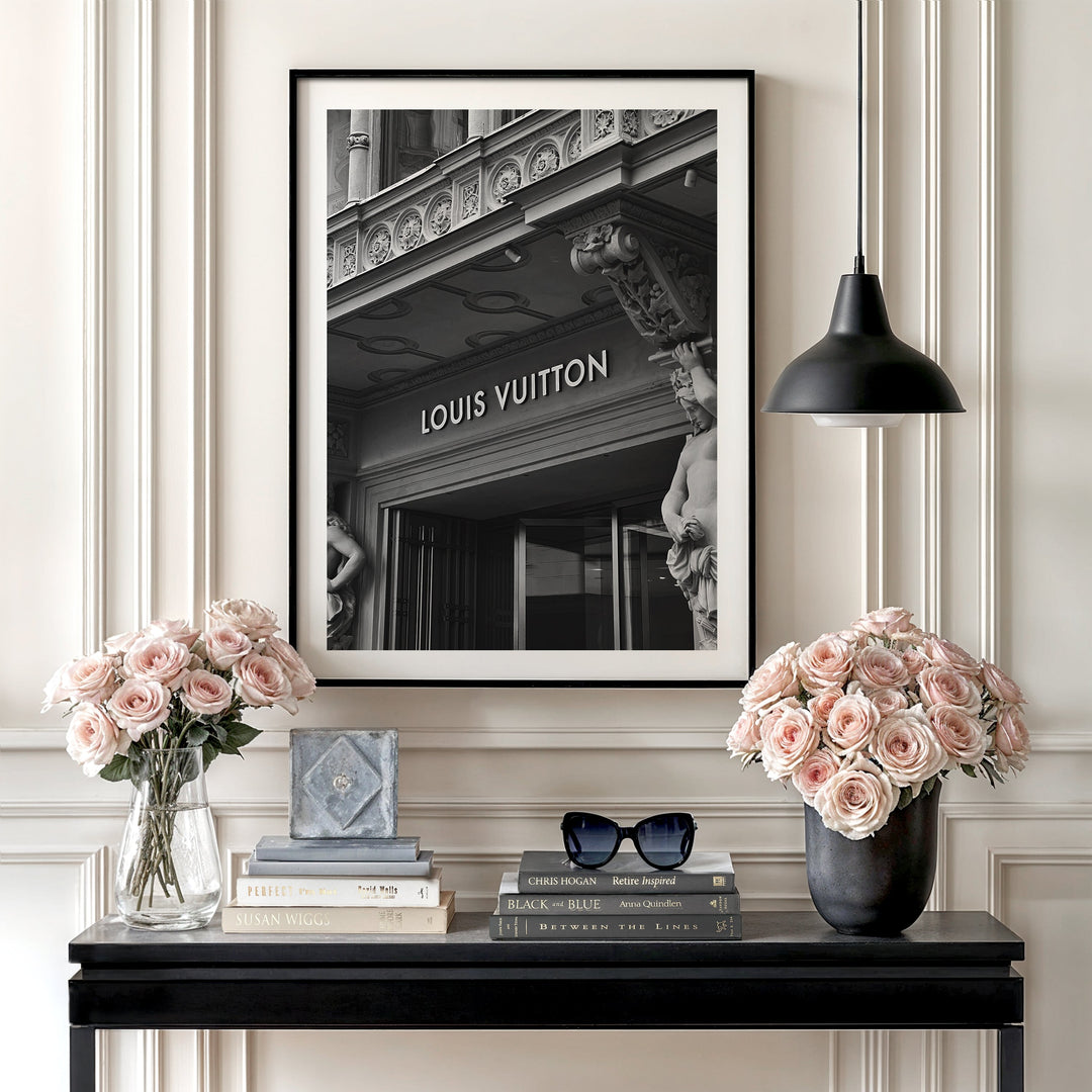 Luxury wall art with a black and white photo of a Louis Vuitton boutique and roses in a minimalist interior