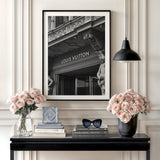 Luxury wall art with a black and white photo of a Louis Vuitton boutique and roses in a minimalist interior