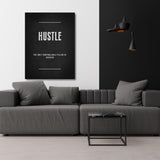 HUSTLE motivational canvas print in a modern living room with a gray sofa and black pendant lights.