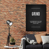 GRIND motivational wall art with a definition quote hanging on a brick wall in an industrial living room.
