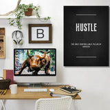 HUSTLE motivational wall art above a wooden desk with a bull figure and green indoor plant.