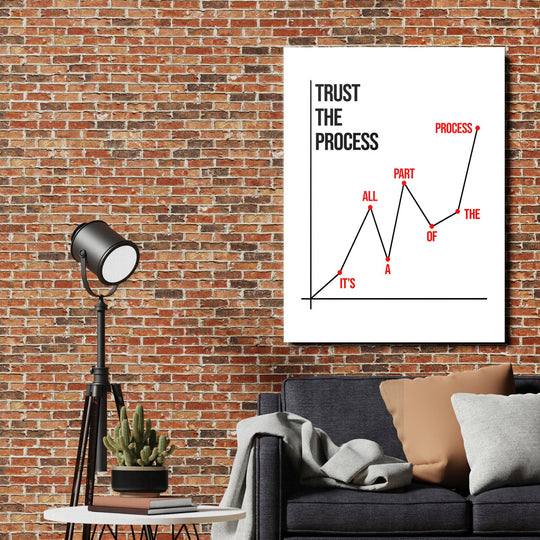 Motivational wall art with a minimalist chart and the quote “Trust the Process” in a loft living room