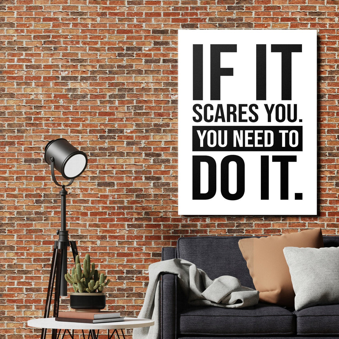 Motivational canvas print with a black-and-white quote on a brick wall in an industrial living room with a designer floor lamp
