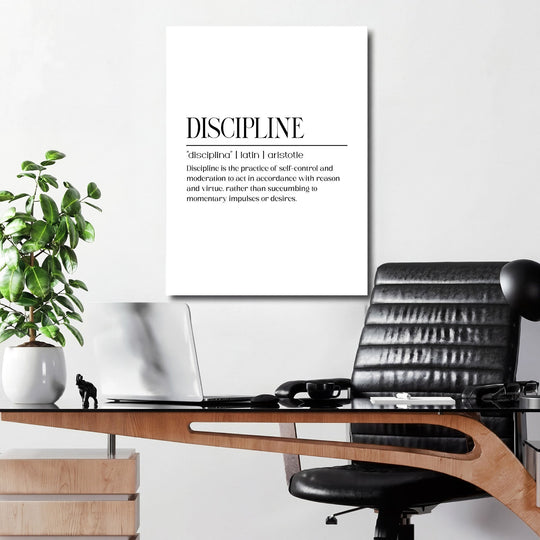 DISCIPLINE motivational wall art above a work desk with a laptop and green plant in a modern office