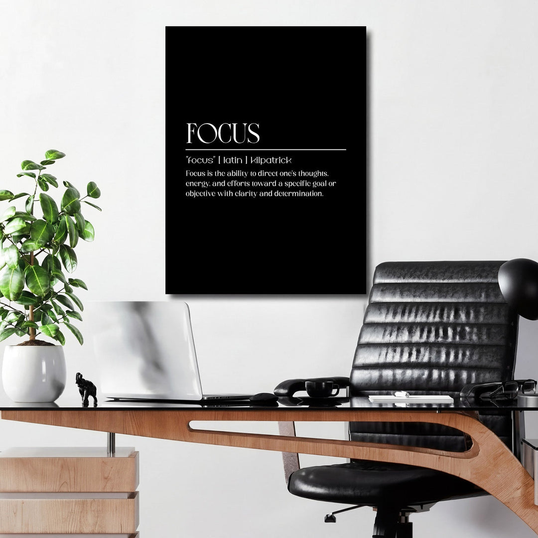 FOCUS motivational wall art with minimalist typography and definition, hanging in a study above a desk with a laptop and plant