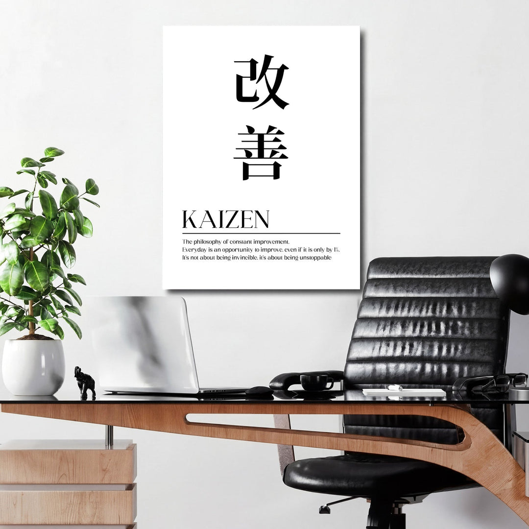 Kaizen motivational canvas wall art with Japanese characters and an English quote in an office above a desk with a laptop and plant