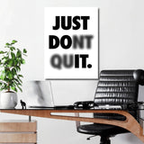 Just Don’t Quit black and white motivational canvas print above a work desk in an office