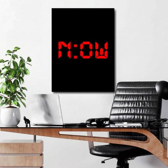 Motivational wall art with minimalist NOW lettering above a desk in a modern interior