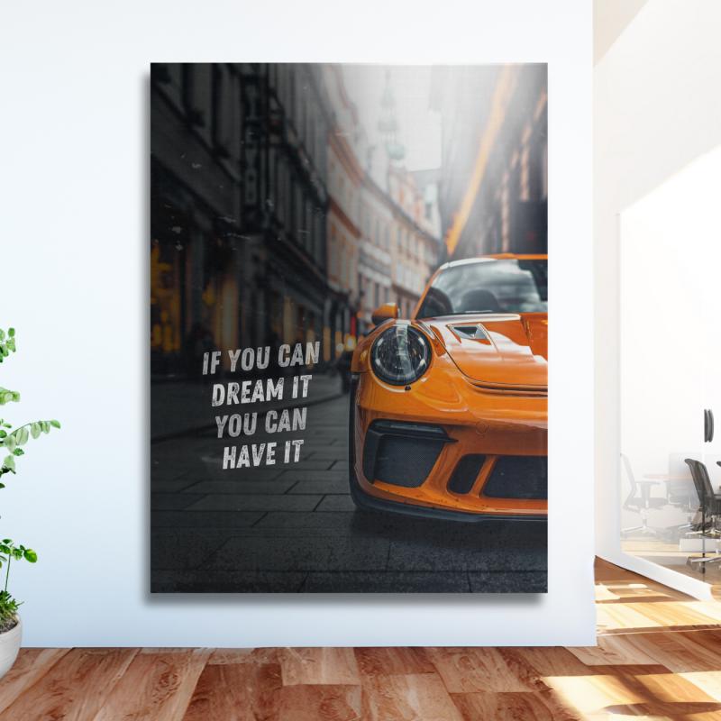Motivational canvas wall art with an orange Porsche, English quote and urban background in a modern office.