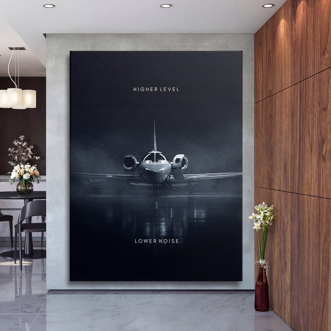 Motivational canvas print in a luxury living room with a business jet from the front and the text “Higher Level, Lower Noise”