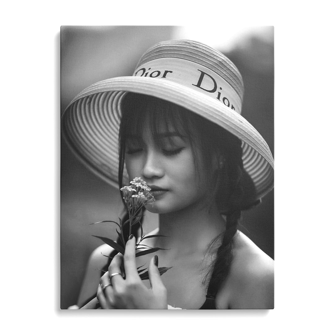 Modern canvas print with a black and white portrait of a woman in a hat holding a flower