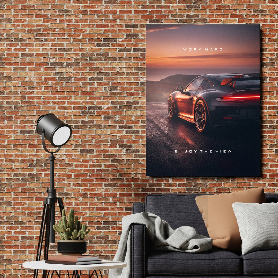 Motivational wall art with luxury sports car at sunset above sofa in an industrial living room