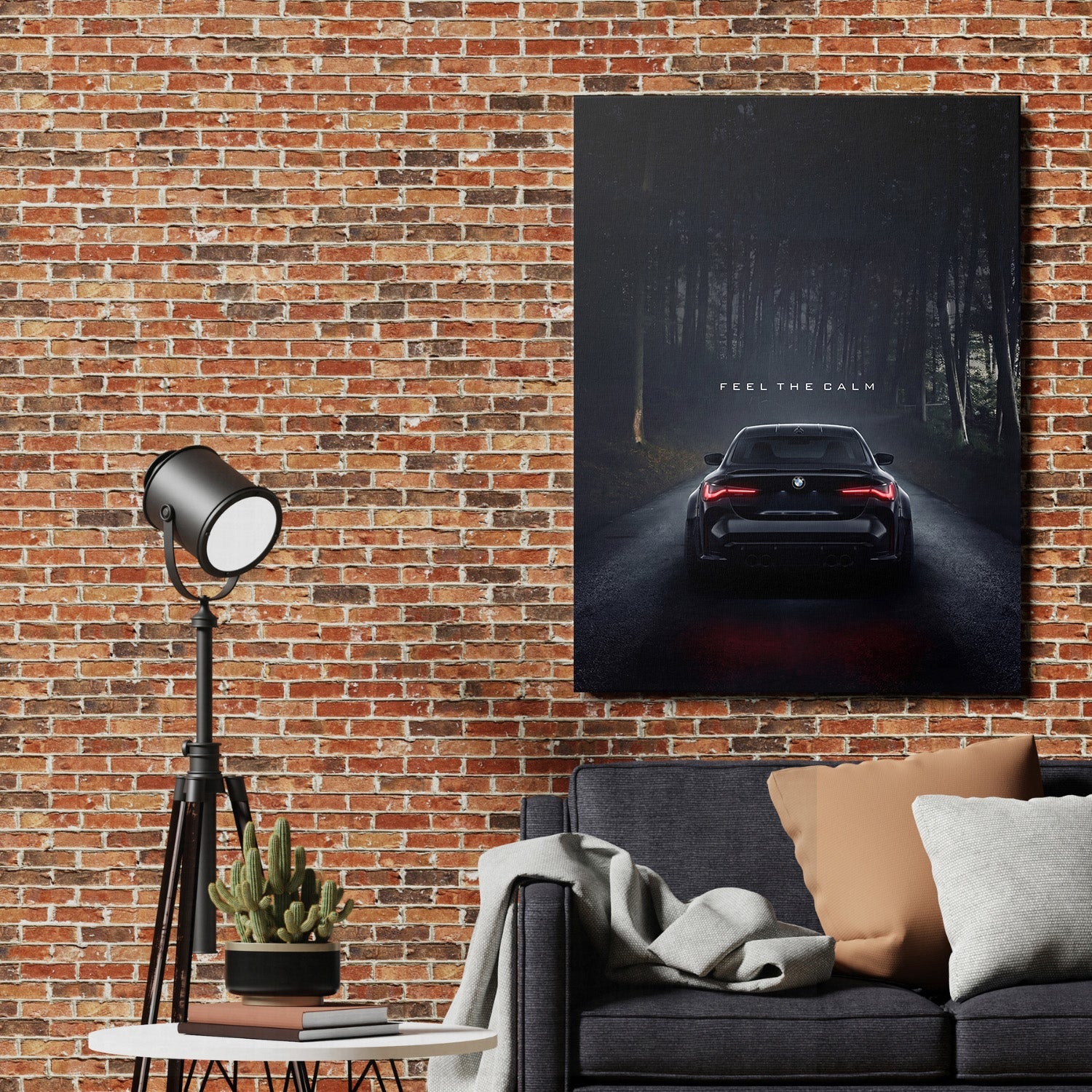 Motivational canvas print with a black BMW on a dark forest road and the quote “Feel the Calm” in a living room