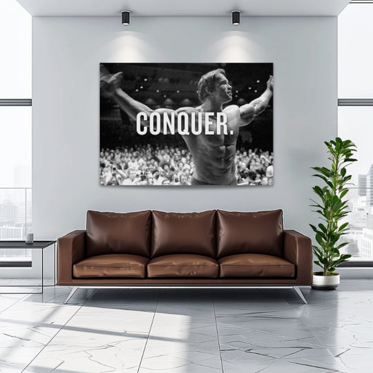 Motivational wall art with Arnold Schwarzenegger, a bodybuilder with outstretched arms and the word CONQUER.