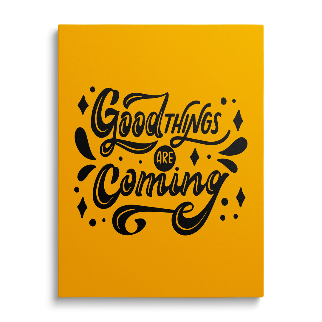 Motivational canvas print with the black phrase “Good things are coming” on a yellow background, front view