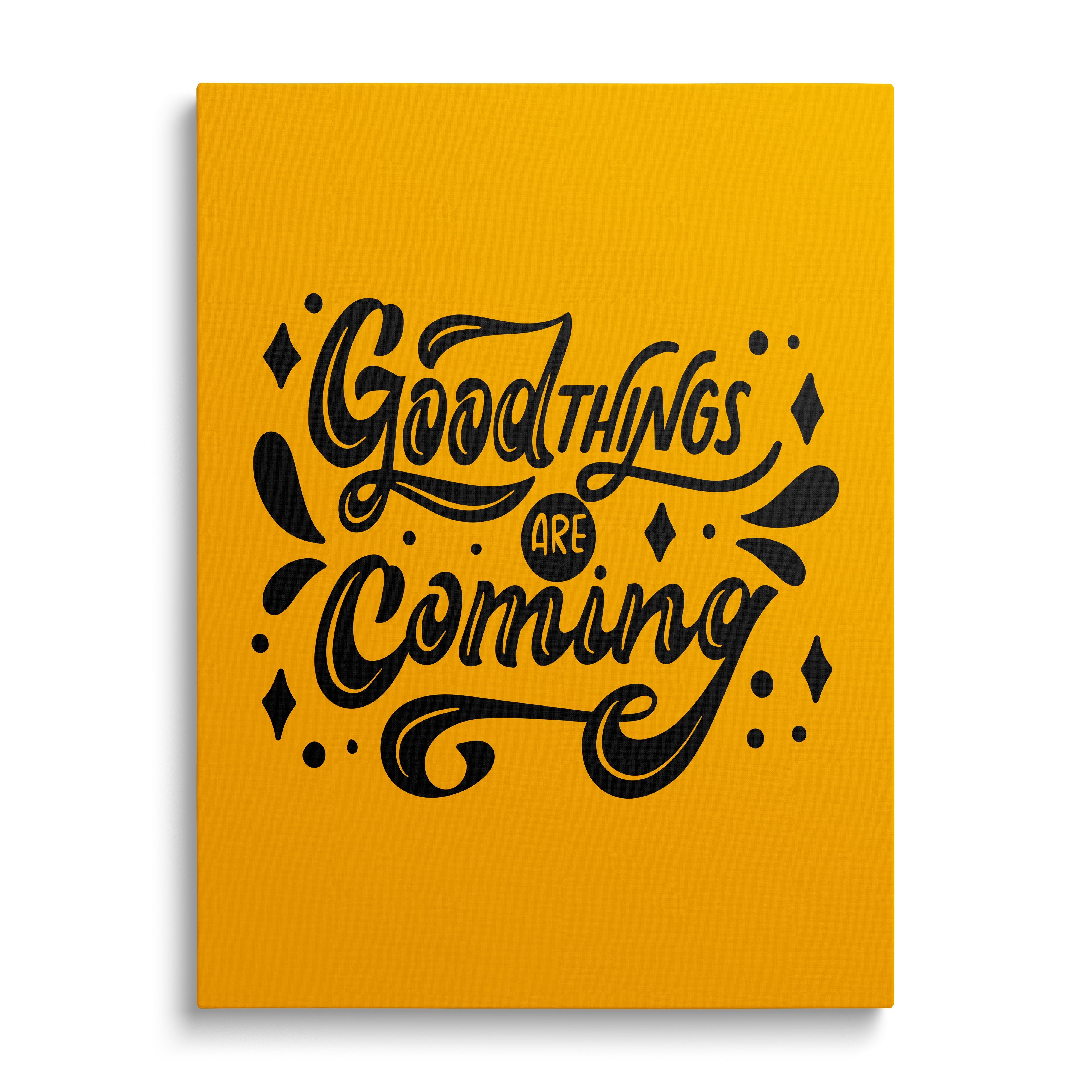 Motivational canvas print with the black phrase “Good things are coming” on a yellow background, front view
