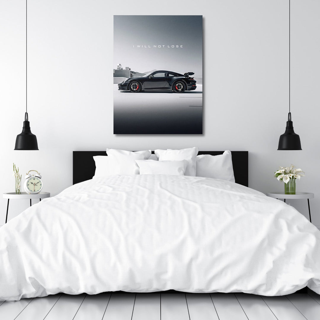 Motivational canvas wall art with black sports car and text I WILL NOT LOSE hanging in a white bedroom above the bed