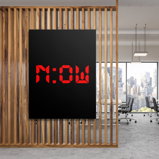 Motivational canvas print with red NOW lettering on a black background in a modern office