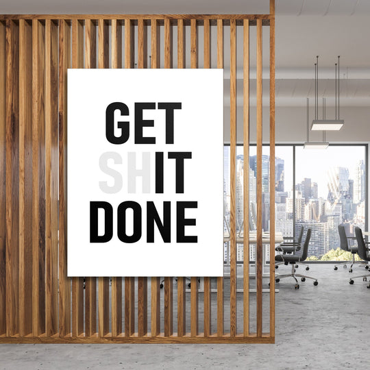 GET SHIT DONE motivational canvas wall art hanging behind wooden slats in a modern office