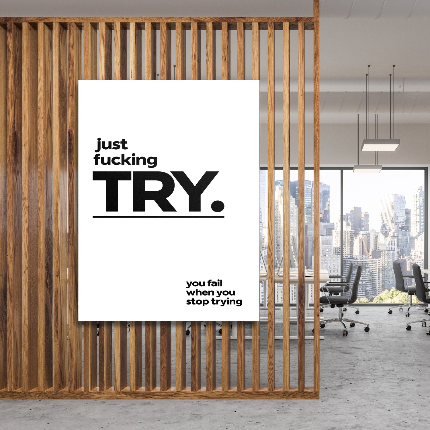 Motivational canvas print with a bold quote in a modern office behind wooden slats with a city view