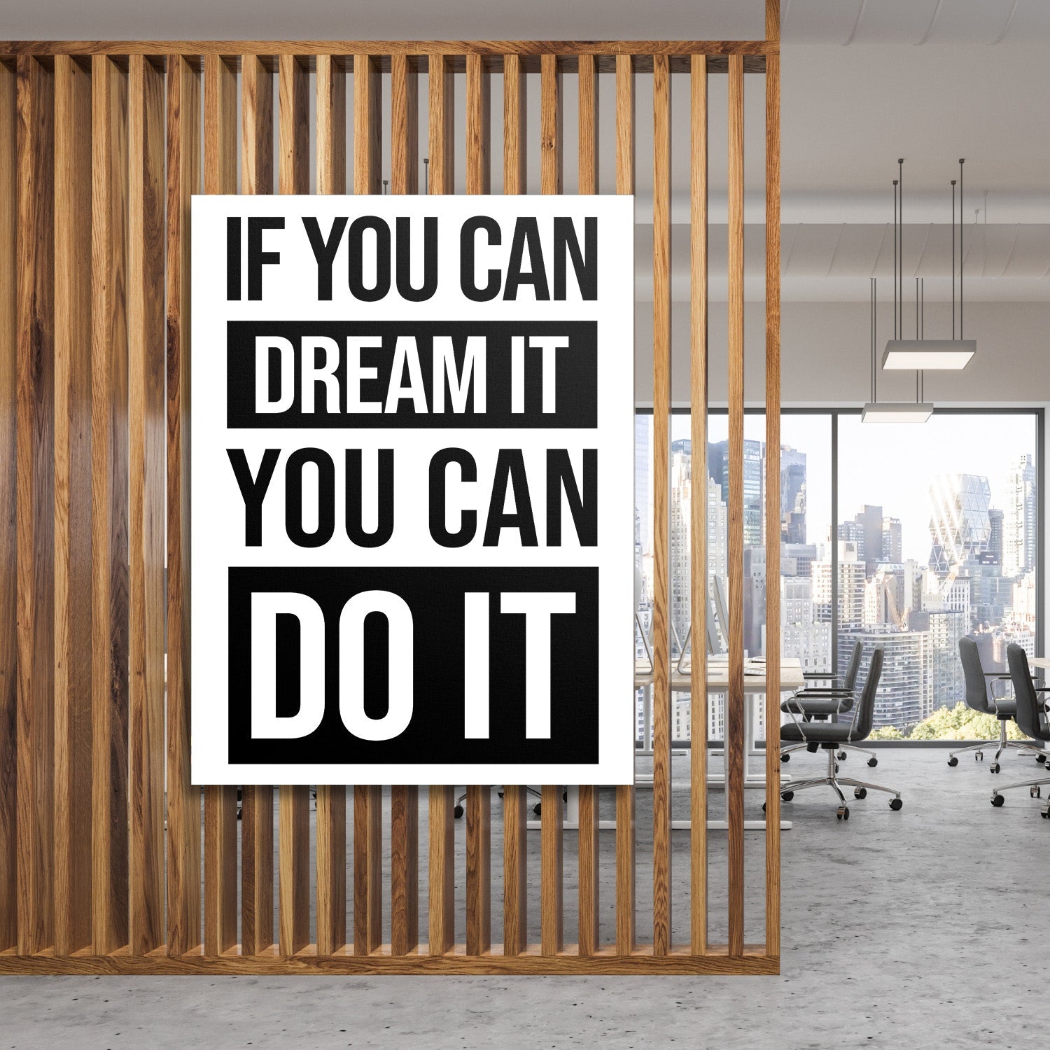 Motivational canvas wall art with a black and white quote in a minimalist modern office