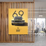 Motivational canvas wall art with a yellow Ford Mustang Boss 302 number 69 hanging in a modern office
