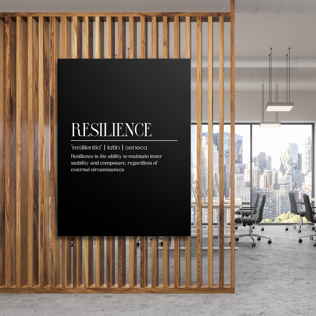 Motivational canvas print with a Latin quote about resilience, hanging on a wooden wall in a modern office