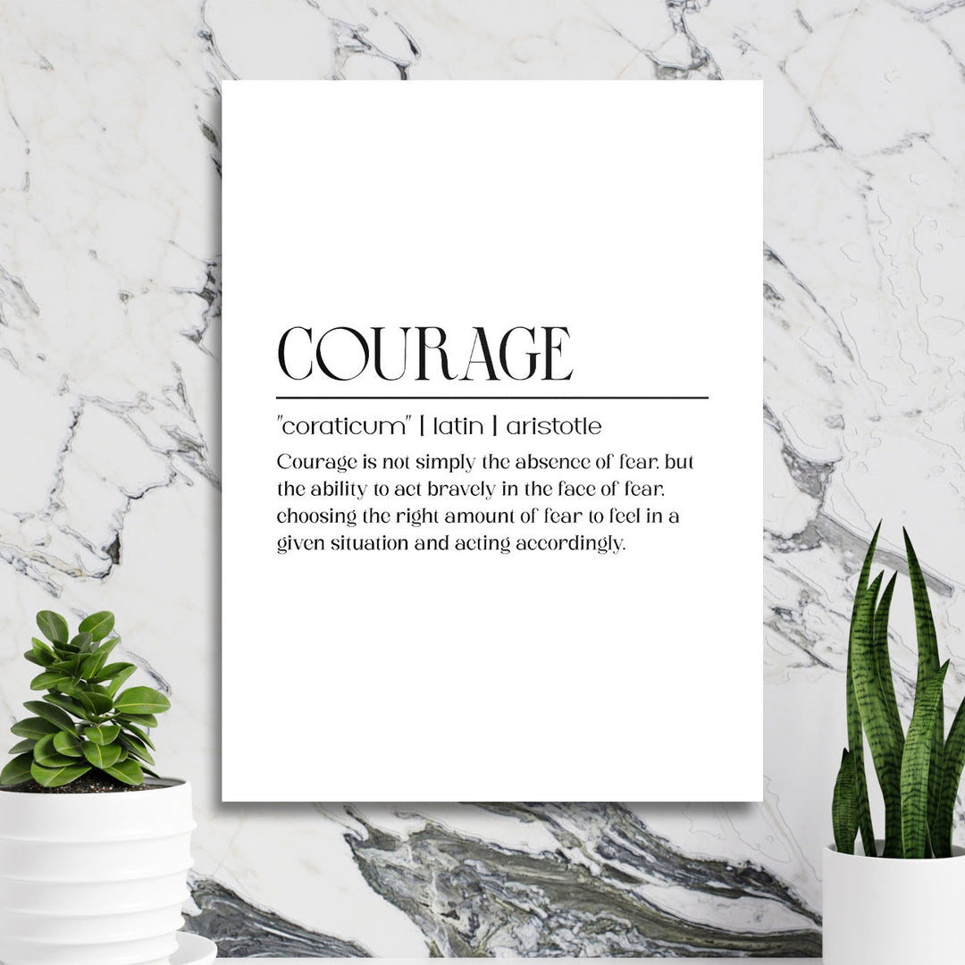 Motivational wall art with a “Courage” quote in a minimalist interior with a marble wall and green houseplants