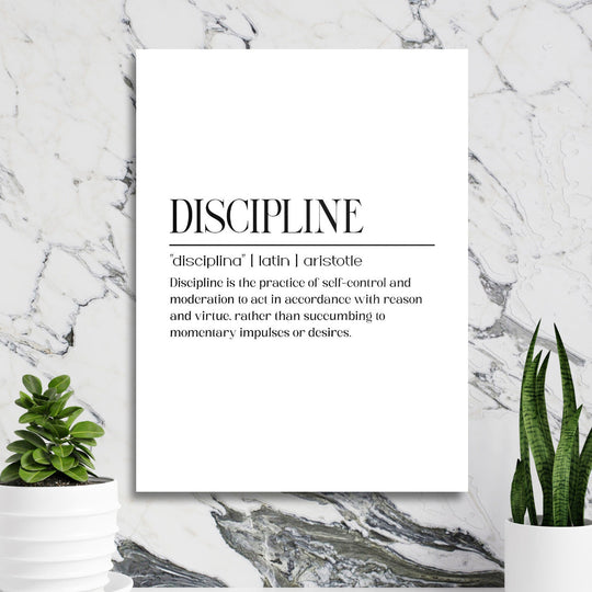 DISCIPLINE black and white motivational wall art on a marble wall near a work corner with plants