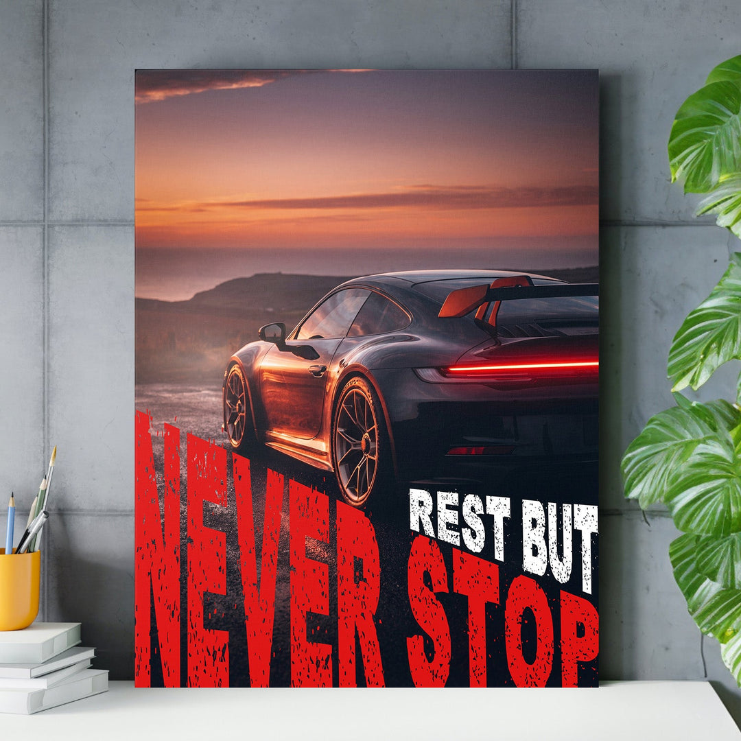 Motivational wall art with a black sports car at sunset and red “Never Stop” text
