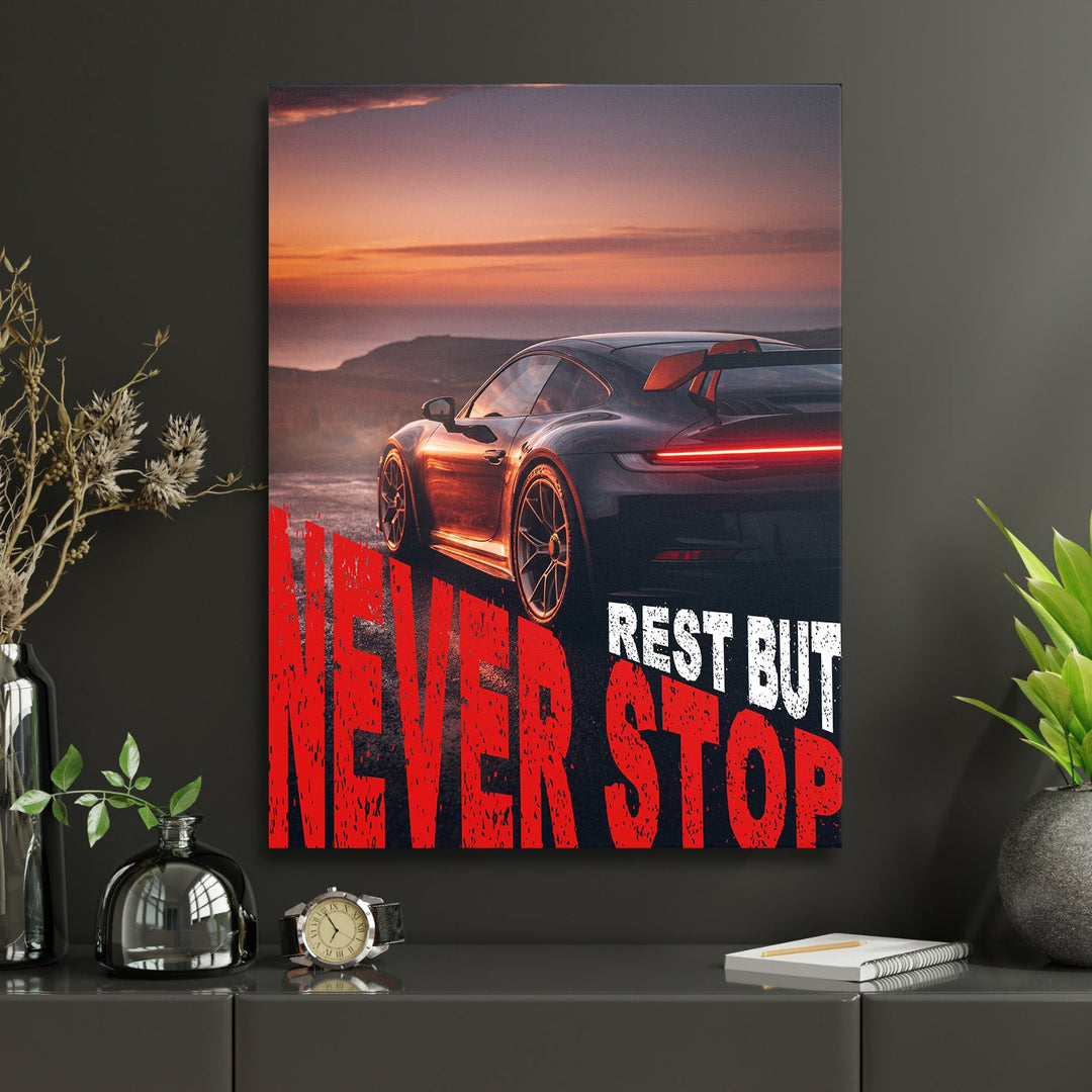 Motivational wall art with a black sports car at sunset and bold “Never Stop” text
