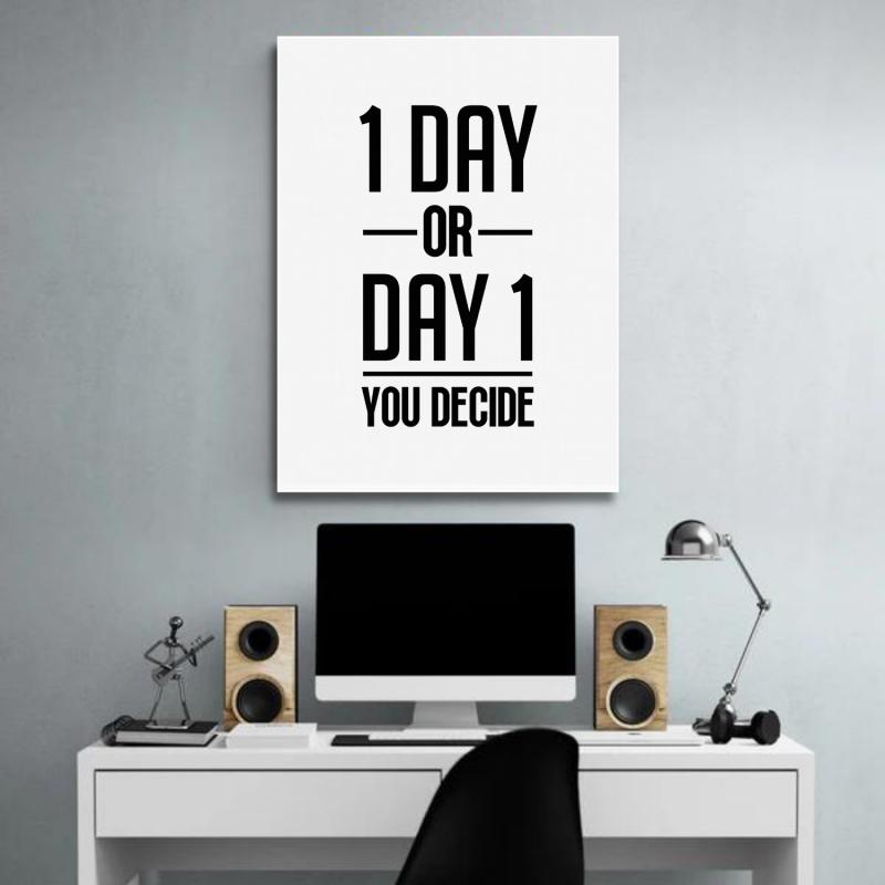 “1 Day or Day 1” motivational wall art above a desk with a monitor, lamp and wooden speakers.