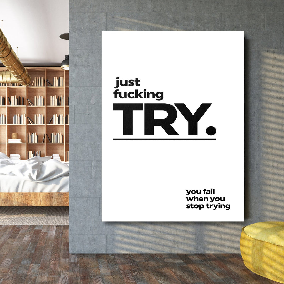Motivational wall art with a black-and-white minimalist “just fucking TRY” quote in an industrial interior