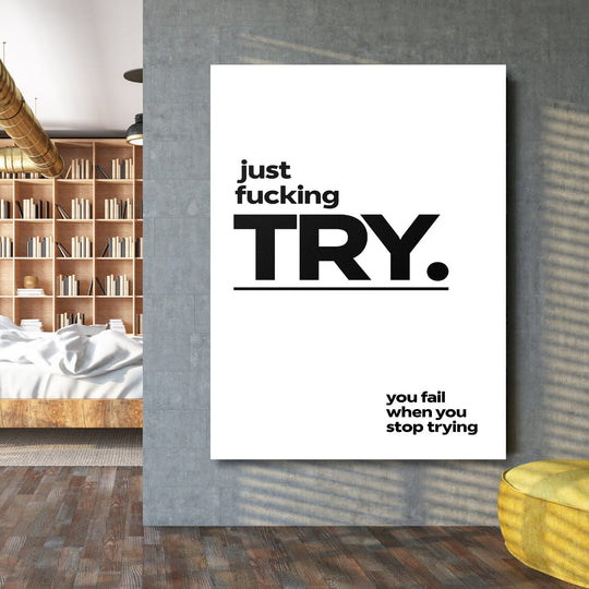 Motivational wall art with a black-and-white minimalist “just fucking TRY” quote in an industrial interior