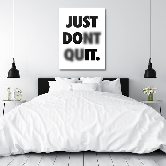 Black and white motivational quote wall art above a bed in a minimalist bedroom