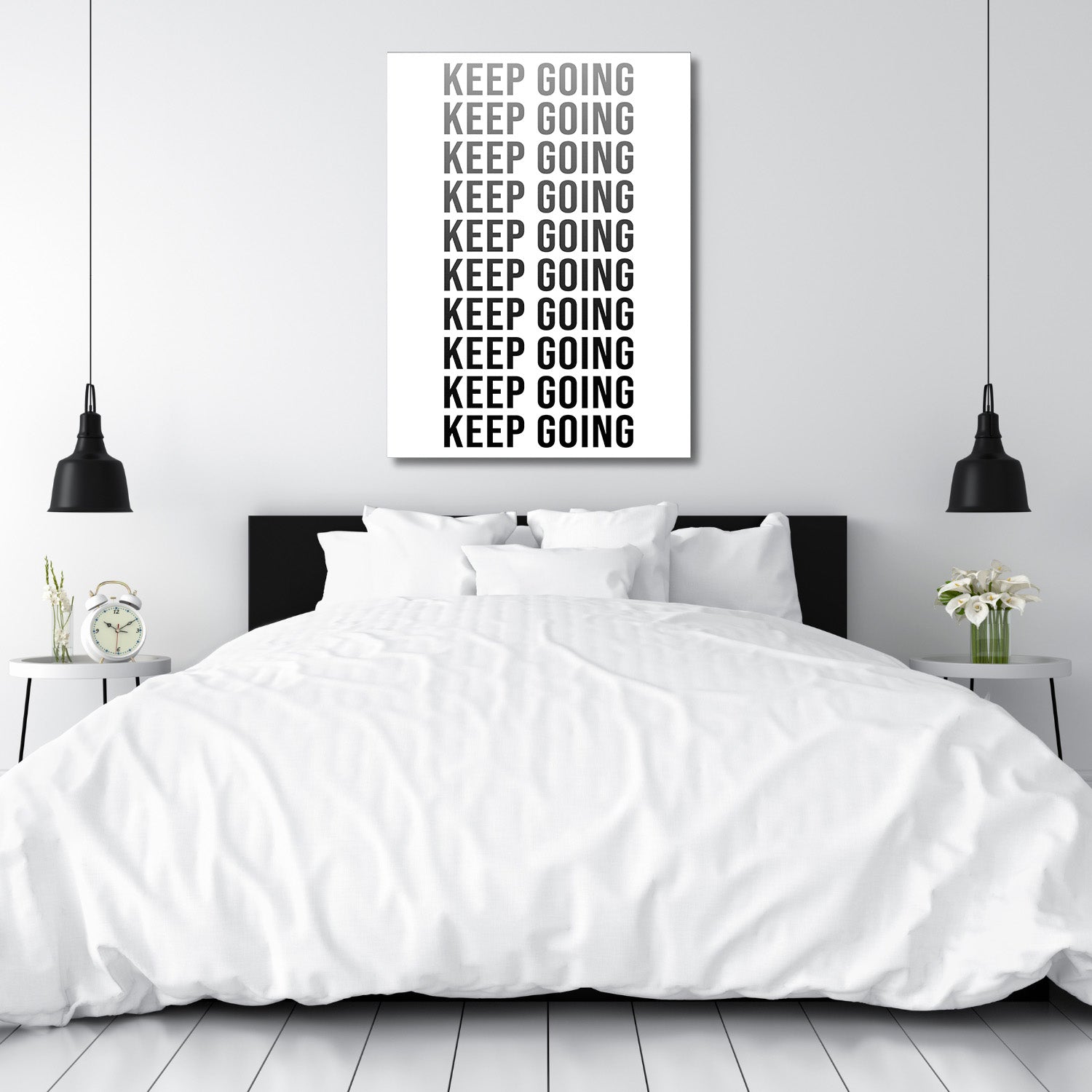 KEEP GOING motivational canvas wall art above a bedroom bed, modern black and white decor in a minimalist interior