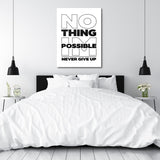 Black and white “NO THING IM POSSIBLE NEVER GIVE UP” motivational canvas wall art hanging above a bedroom bed