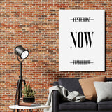 Motivational wall art with NOW text and crossed-out Yesterday and Tomorrow on an industrial brick wall.